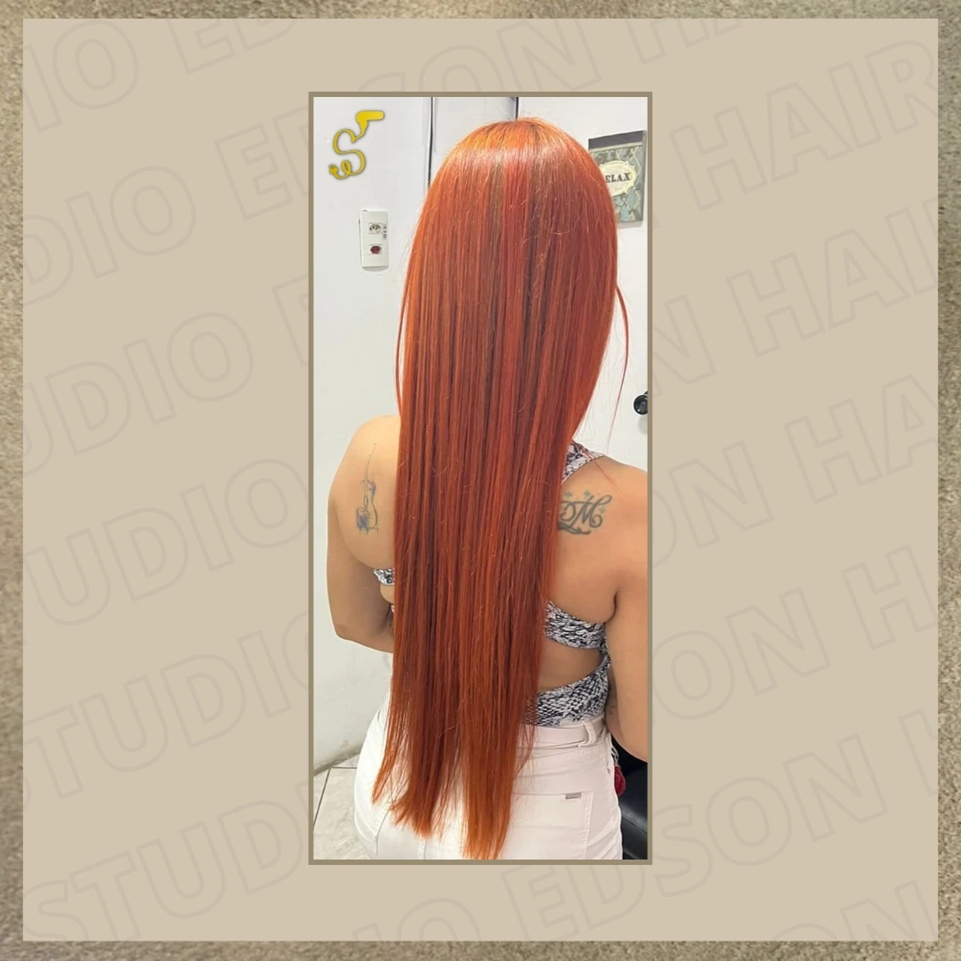 Mulher vista de costas exibindo cabelo super longo, liso e alinhado na cor ruivo acobreado vibrante, com corte reto nas pontas.